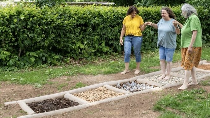 Ortsvorsteherin Ursula Haa� begibt sich mit geschlossenen Augen über das Barfußpfädel