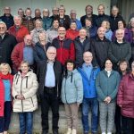 Jahrgang 1956 feiert Wiedersehen Große Seniorengruppe lächelt gemeinsam für ein Gruppenfoto im Freien.
