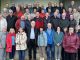 Große Seniorengruppe lächelt gemeinsam für ein Gruppenfoto im Freien.