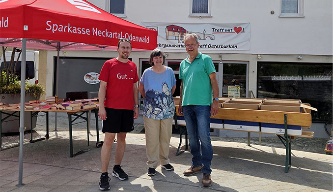 Drei Personen vor dem Mehrgenerationen-Treff Osterburken am Bücherstand.