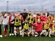 Junge Fußballspieler in Trainingskleidung posieren fröhlich für ein Gruppenfoto.