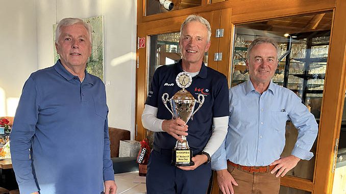 Drei Männer posieren lächelnd mit einem Wanderpokal.