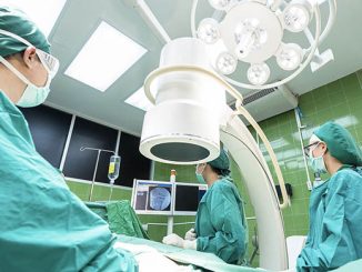 Chirurgenteam im Operationssaal mit mobilem C-Bogen Röntgengerät